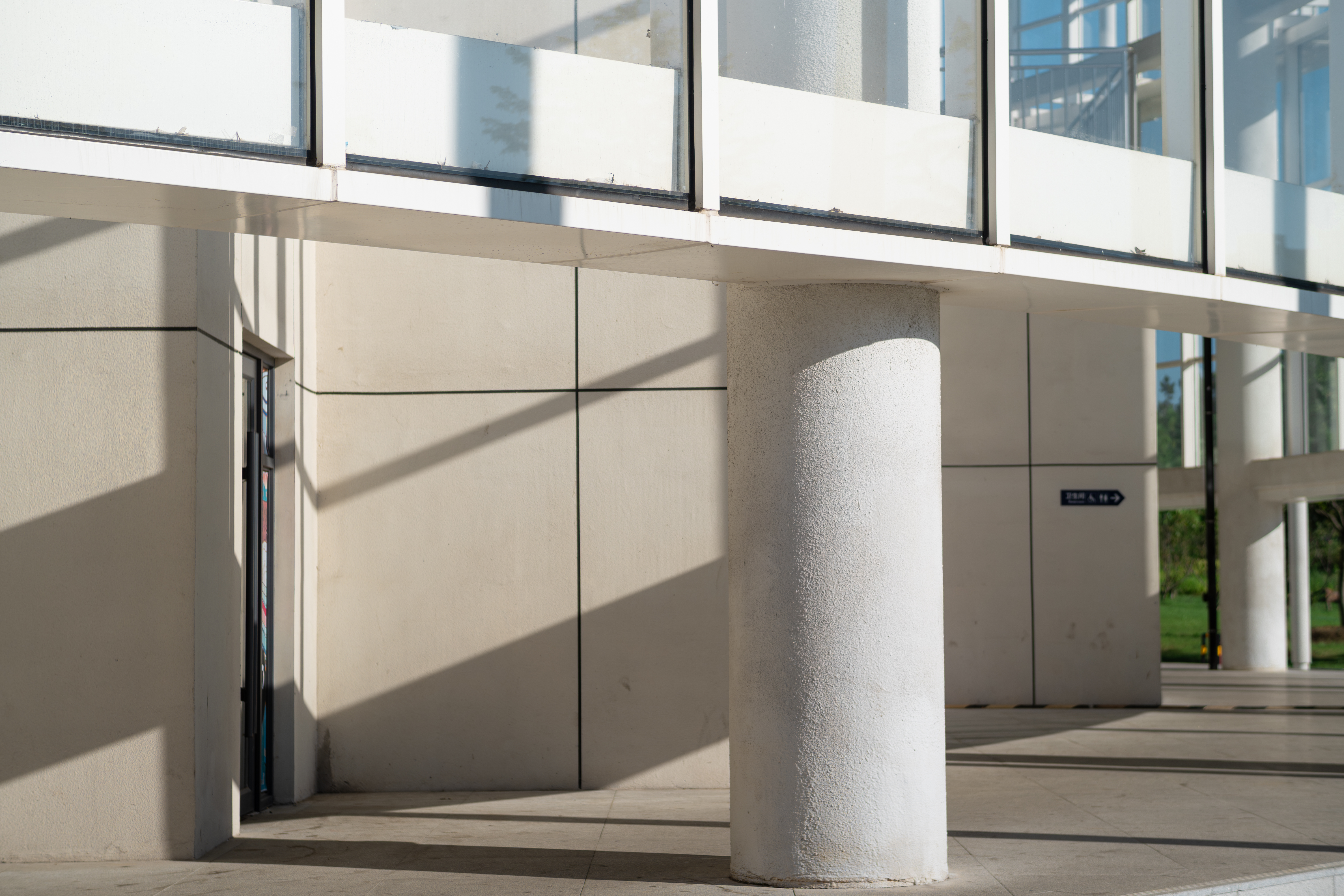 Concrete columns and glass facade casting sharp shadows